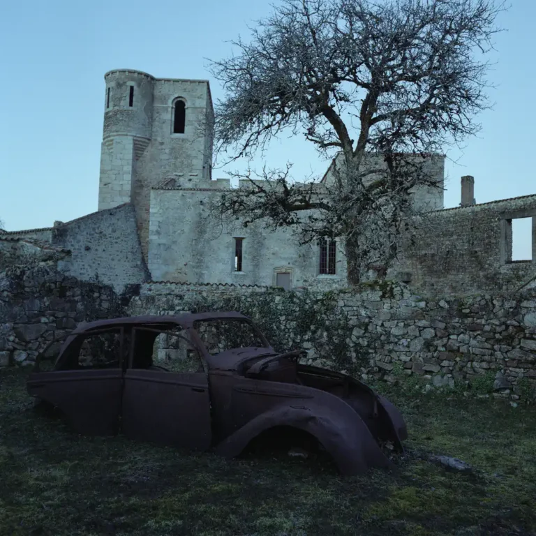Ruines d’Oradour-sur-Glane avec une voiture calcinée devant l’église, photographie de Floriane Duong